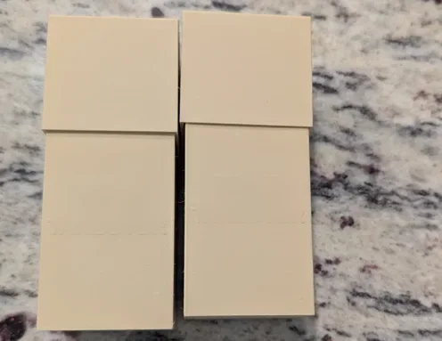Two 3D-printed card cases with a raised name on the lid